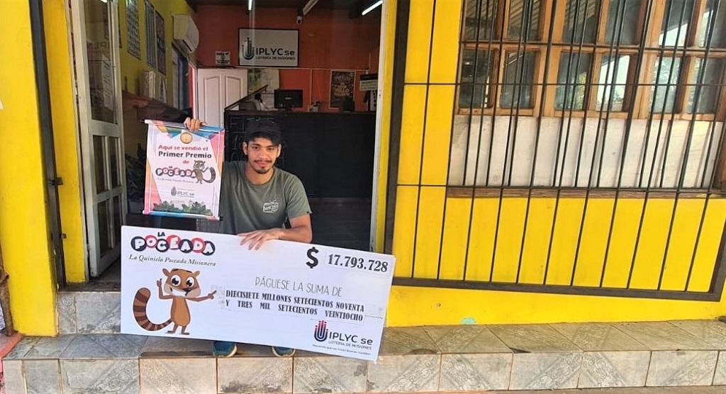 Marcelo Valenzuela, vendedor del primer premio, muestra el cheque sentado en la puerta de la Agencia.