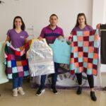 Voluntarios muestran mantas que son acercadas a quienes más necesitan.