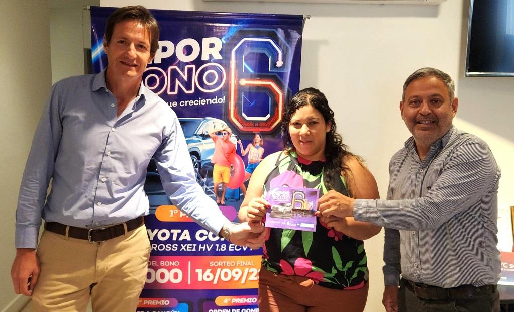 Ganadora recibe premio mayor del Deporbono 6 de manos de Héctor Decut y Héctor Corti.