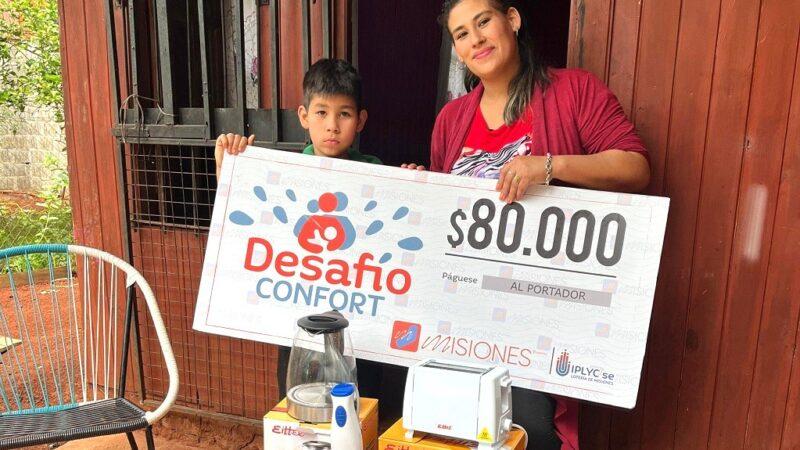 María muestra su cheque junto a su hijo, con el premio ampliar una habitación para el.