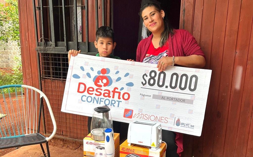 María muestra su cheque junto a su hijo, con el premio ampliar una habitación para el.