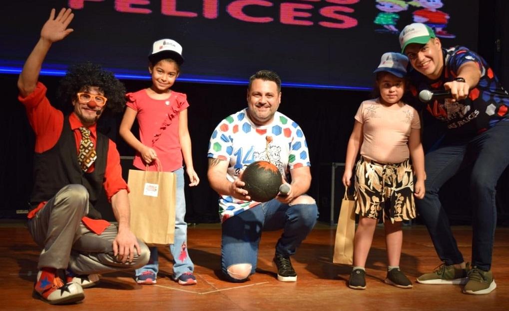 Dos niñas reciben sus obsequios de manos de Tata Pó y Marcelo Ledesma.