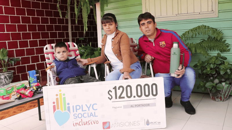 Bruno junto a sus papás muestran su cheque. Con el dinero comprarán un aire acondicionado para él.