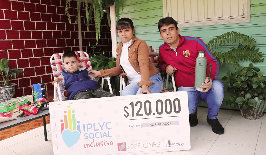 Bruno junto a sus papás muestran su cheque. Con el dinero comprarán un aire acondicionado para él.