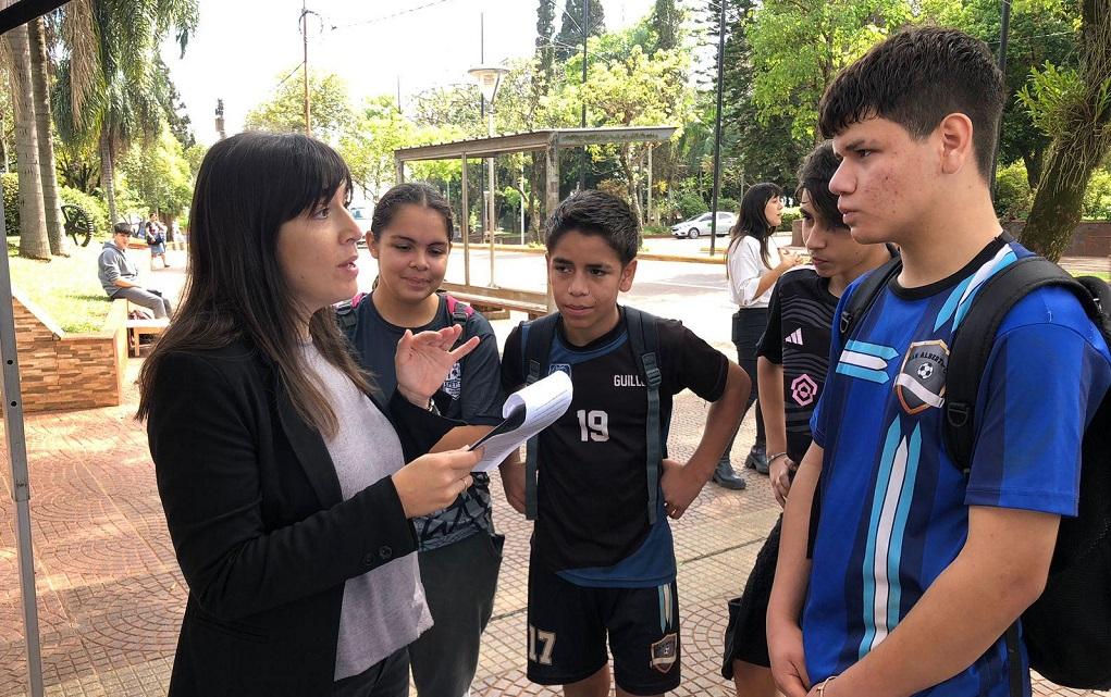 María Belén Díaz Beltrán charla con un grupo de adolescentes sobre juego saludable en la plaza.