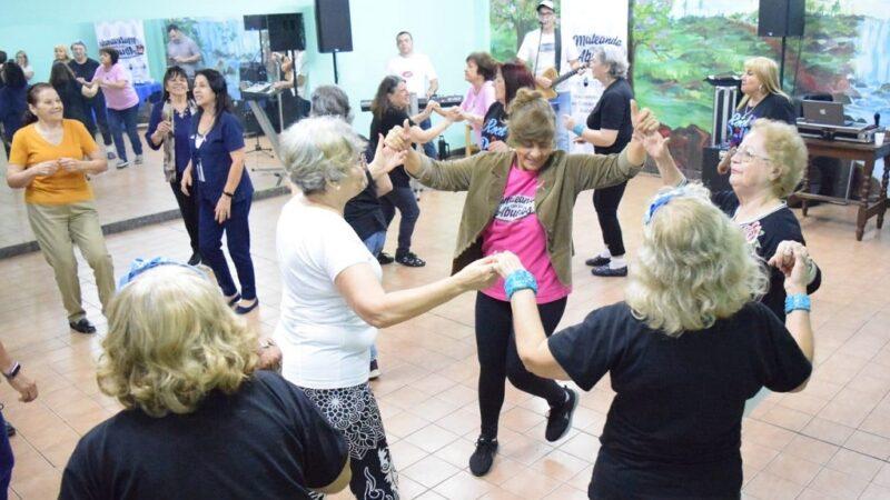 Grupo de abuelos bailan en ronda.