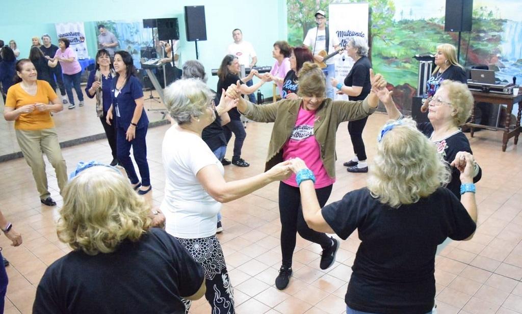 Grupo de abuelos bailan en ronda.