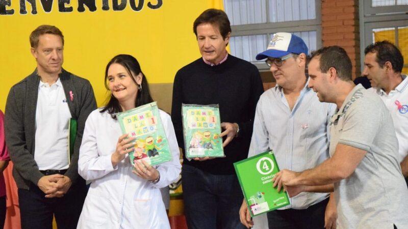 Una docente recibe de Héctor Decut libros y kits de muebles escolares.