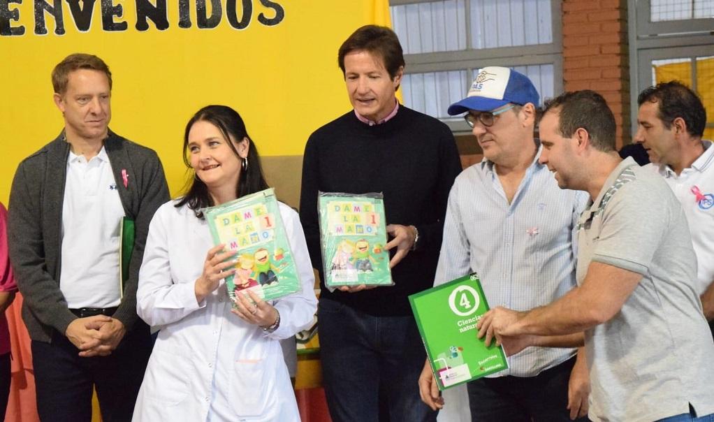 Una docente recibe de Héctor Decut libros y kits de muebles escolares.