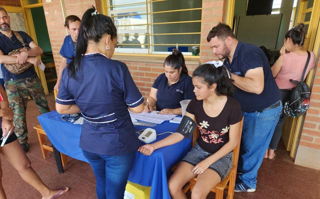 Personal de salud mide la presión a vecina y atiende a otros que se acercaron al operativo.