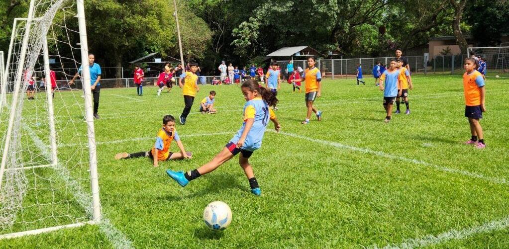 Niña patea la pelota durante un partido.