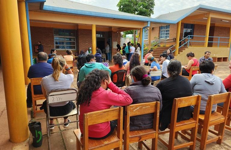 Vecinos sentados en sillas esperan a ser atendidos durante el operativo en el barrio Santa Helena.