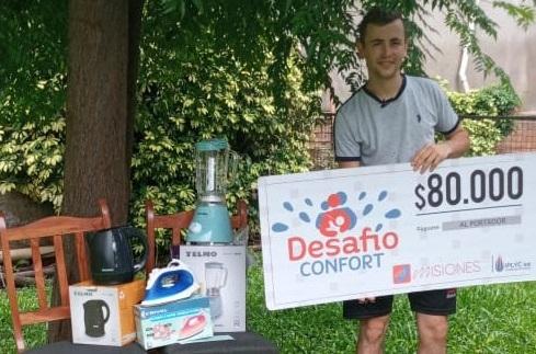 Alfredo feliz con su cheque y premios. Usará el dinero para seguir construyendo su casa.