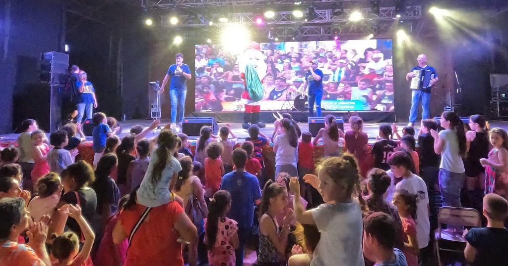 Gurises sobre el escenario frente al público infantil. Fiesta de la Navidad en Alem