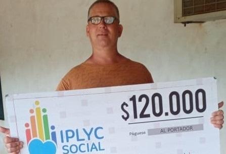 Guillermo muestra su cheque. Usará el dinero para hacer mejoras en su vivienda.