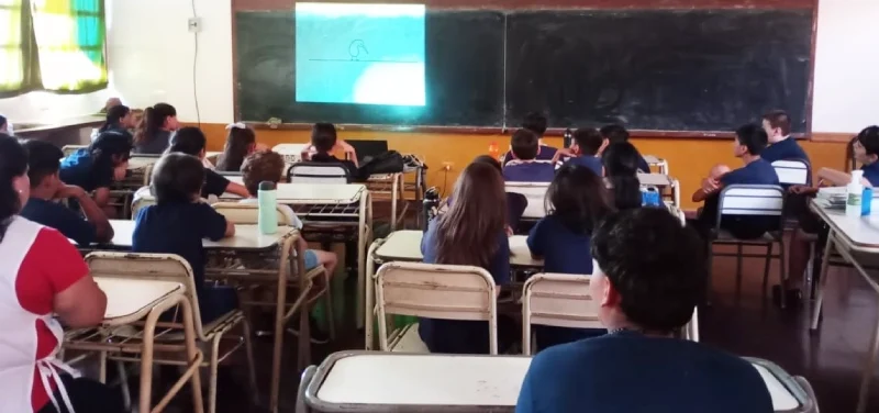 Alumnos de la Escuela 813 miran atentos un video en el aula.