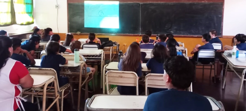 Alumnos de la Escuela 813 miran atentos un video en el aula.