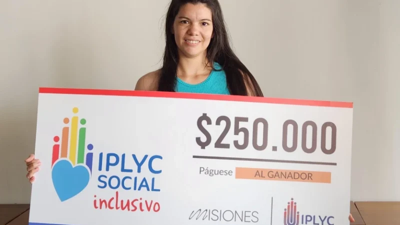 Micaela muestra su cheque. Usará el dinero para seguir construyendo su casa.