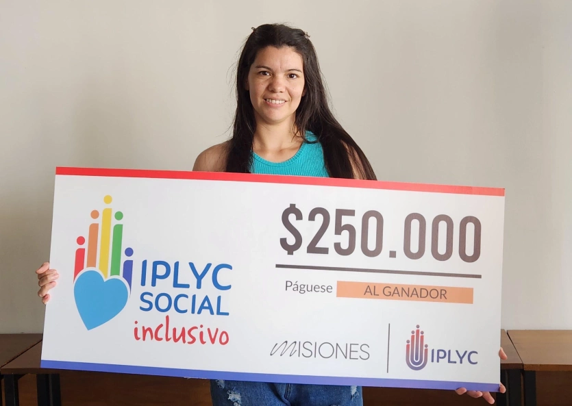 Micaela muestra su cheque. Usará el dinero para seguir construyendo su casa.