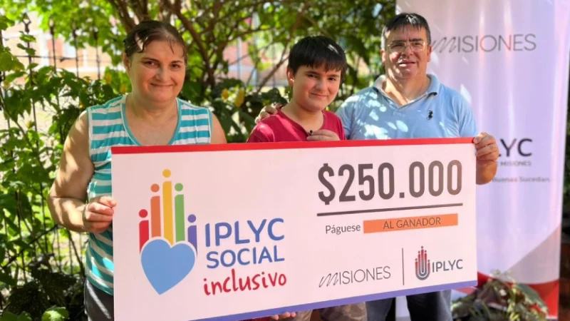 Mauricio con su mamá y su papá muestran sonrientes su cheque.