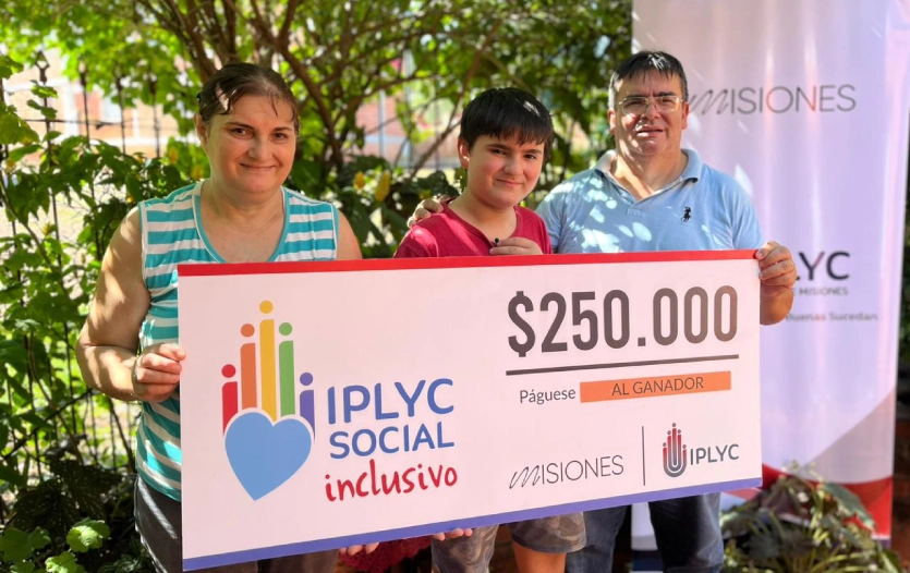 Mauricio con su mamá y su papá muestran sonrientes su cheque.