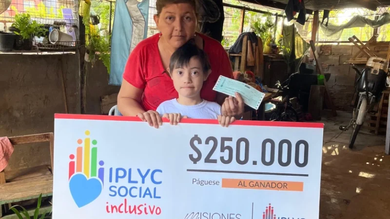 Darian y su mamá muestran su cheque del Inclusivo.