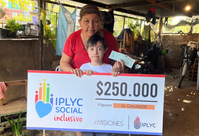 Darian y su mamá muestran su cheque del Inclusivo.