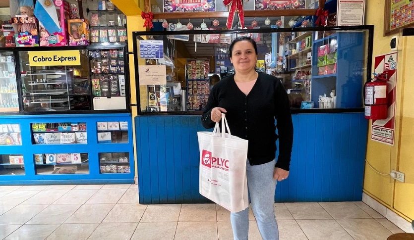 Carolina sonríe dentro de la agencia.