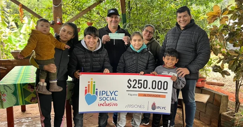 Calixto junto a su familia, sonrientes, muestran su cheque ganador del Inclusivo.