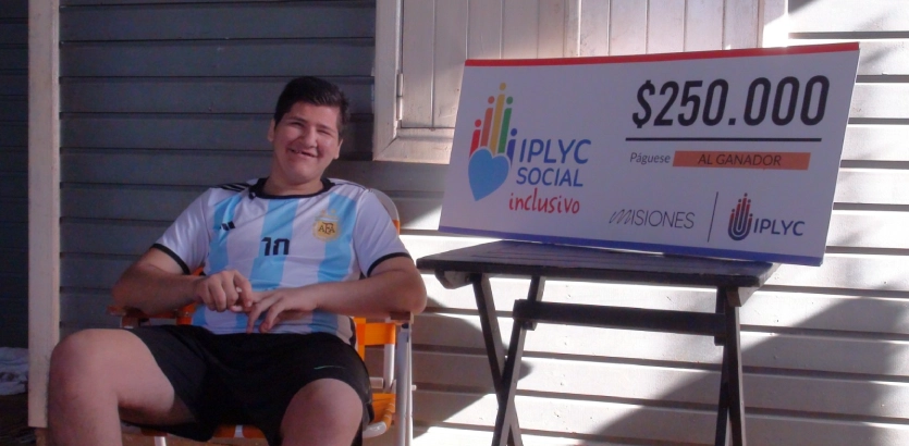 Luciano, ganador del Inclusivo, sonriente junto a su cheque.