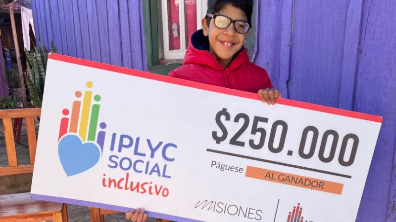 Lucas Páez, sonriente con su cheque de IPLyC Social Inclusivo.