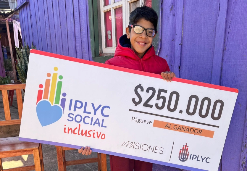 Lucas Páez, sonriente con su cheque de IPLyC Social Inclusivo.