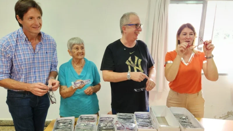 Decut, Passalacqua y Celia Smiak entregan sus anteojos a vecina durante el operativo Mirar mejor.