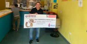 Nelson muestra el cheque ganador de la Poceada en el local de su Agencia 239 de Posadas.