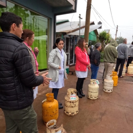 Vecinos con sus garrafas esperan en fila para recargarlas.