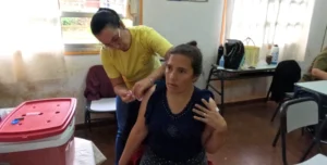 Mujer recibe vacunación,, Operativo Estamos con Vos en 25 De Mayo.