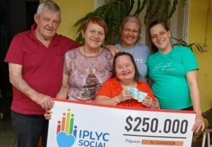 Blanca Robledo, ganadora del Inclusivo rodeada de su familia muestra su cheque.