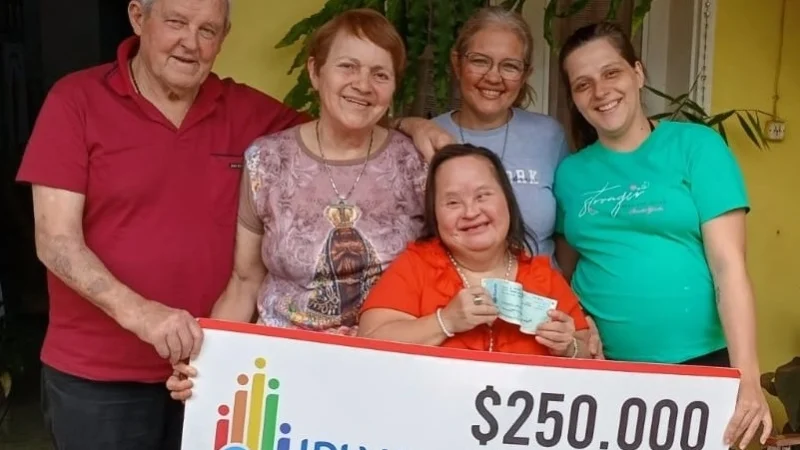 Blanca Robledo, ganadora del Inclusivo rodeada de su familia muestra su cheque.