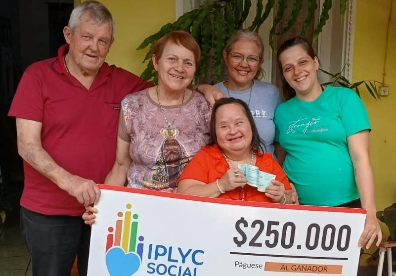 Blanca Robledo, ganadora del Inclusivo rodeada de su familia muestra su cheque.