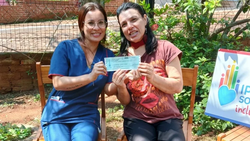 Stella junto a su hermana muestra felìz su cheque de IPLyC Social Inclusivo.