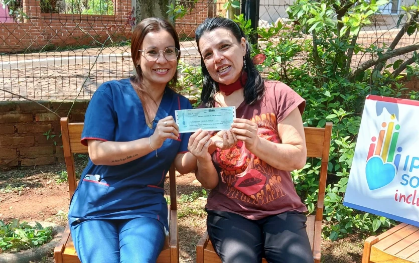 Stella junto a su hermana muestra felìz su cheque de IPLyC Social Inclusivo.
