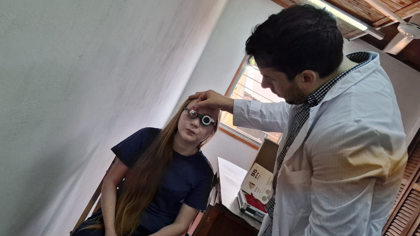 Oftalmólogo prueba graduación con lentes de prueba óptica en una joven. Mirar Mejor - Panambí.