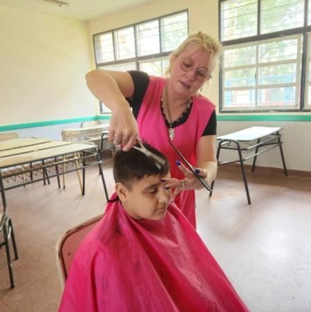 Peluquera realiza corte de cabello a un niño.