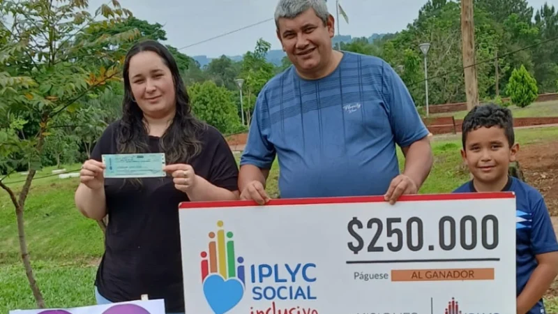 Los papás y el hermano de Milena muestran su cheque de IPLyC Social Inclusivo.