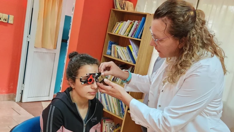 Oftalmóloga prueba graduación con lentes de prueba óptica en una joven. Mirar Mejor - Capioví.