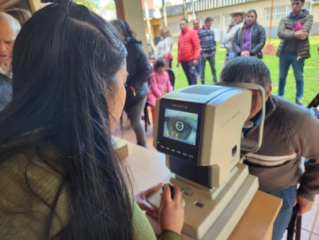 Oftalmóloga controla la vista con autorefractómetro a un vecino.
