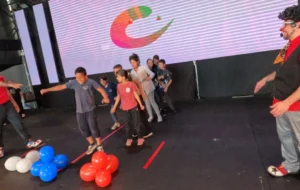 Niños hacen juego con globos junto a Tata Pó. Gurises Felices en la Fiesta de la Madera.