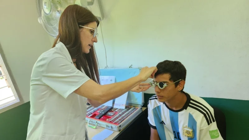Oftalmóloga prueba graduación con lentes de prueba óptica a un joven. Mirar Mejor - Hipólito Yrigoyen.