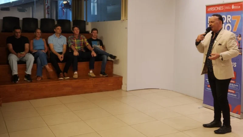Ricardo Vera durante el sorteo del Deporbono 7, Héctor Decut y autoridades presentes observan en la sala de sorteo.