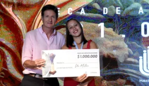 Héctor Decut junto a una deportista que recibe una de las becas.